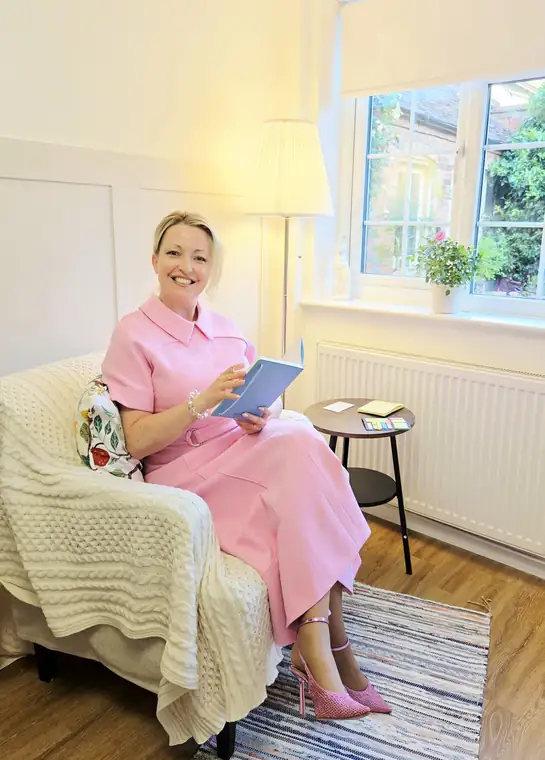 Someone reading in the cream armchair