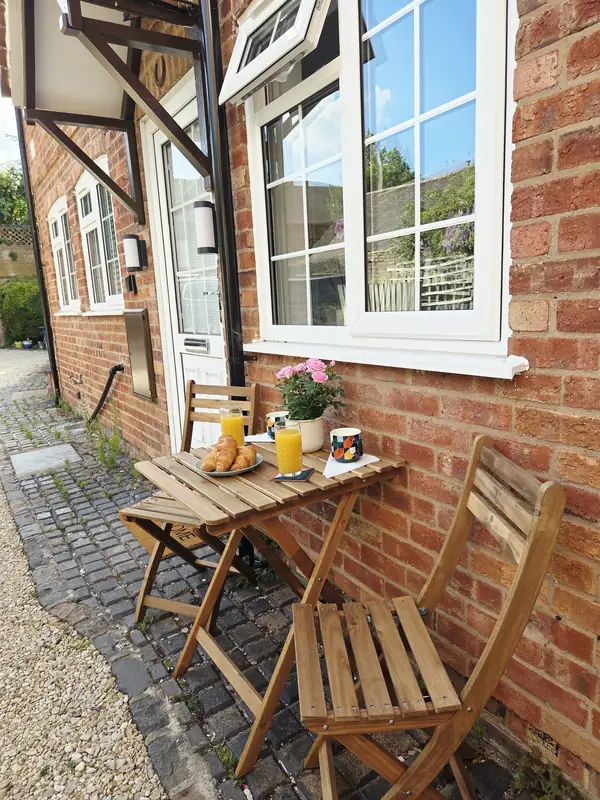 A breakfast table set against the brick front wall