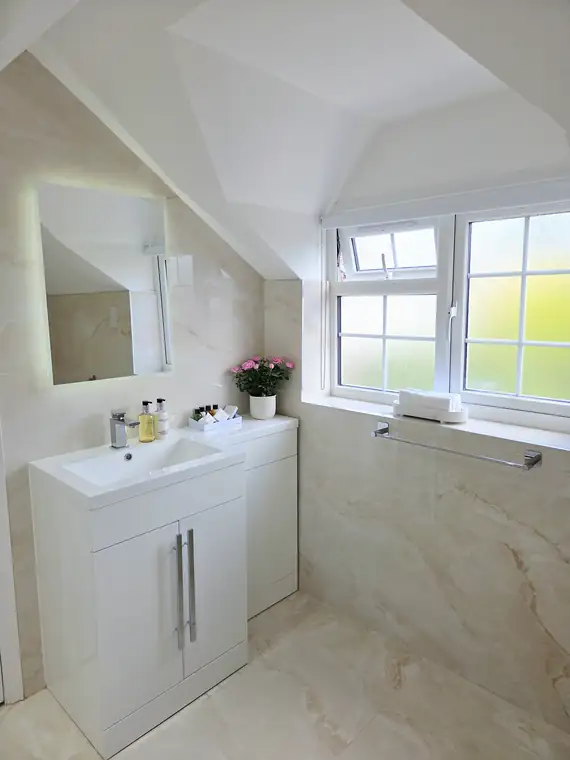 The bathroom vanity unit and lit mirror