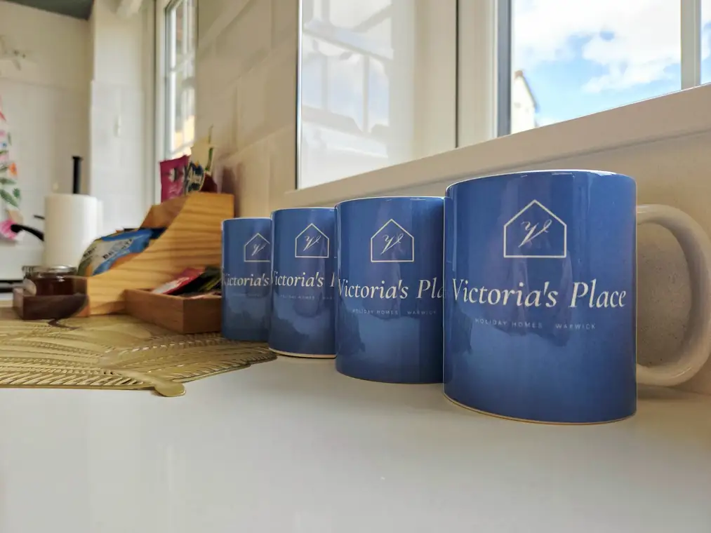 Four Victoria's Place mugs in a row on the worktop