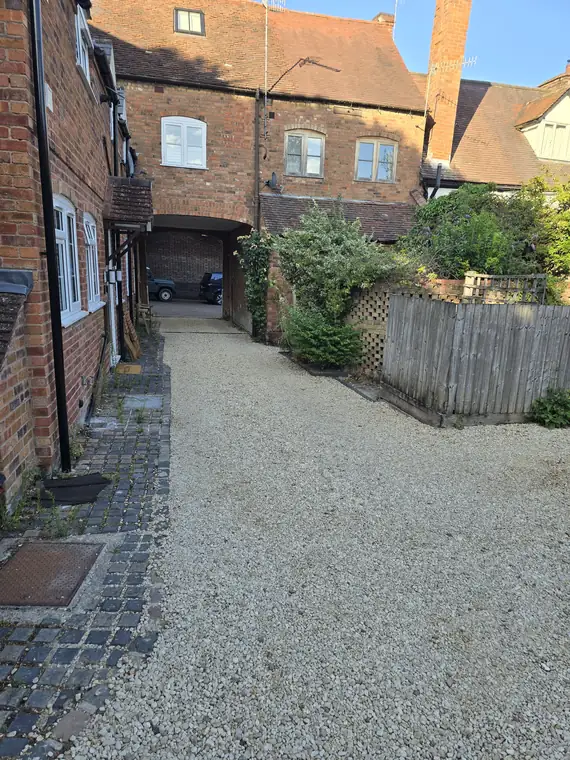 The shared gravelled courtyard looking out through the archway towards Castle Street