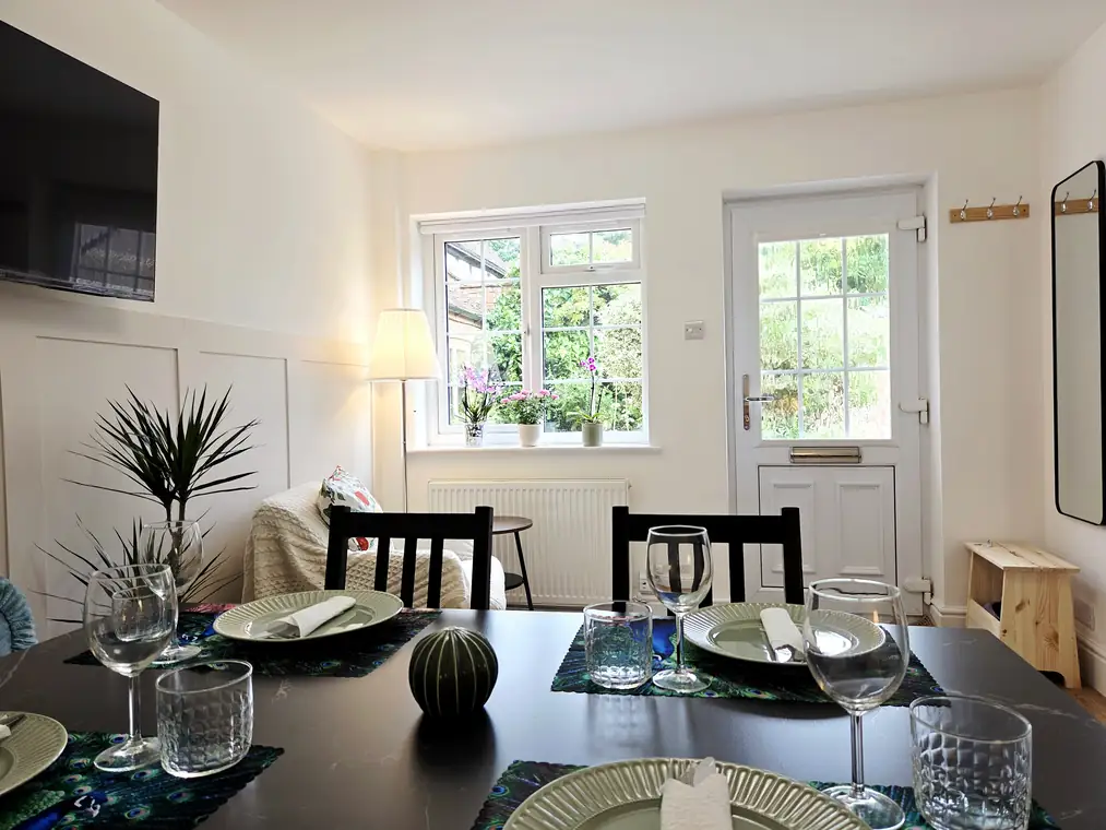 The dining area with the living room and garden door beyond