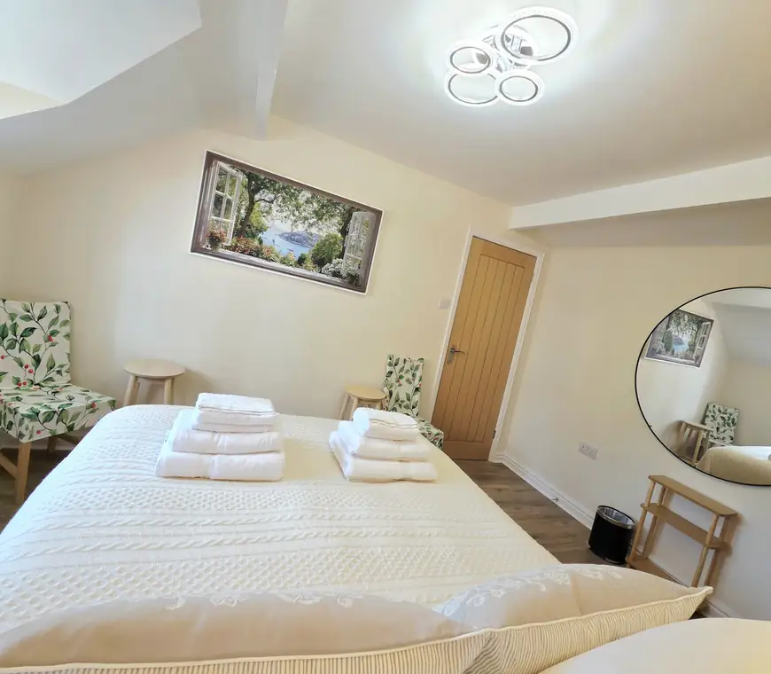The main bedroom with its round mirror and framed print