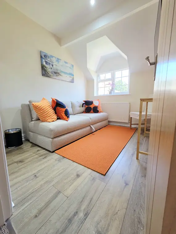 The second bedroom with the grey sofa bed folded away