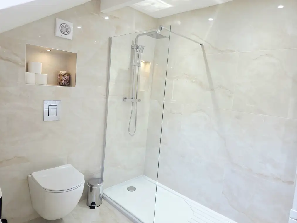 The walk-in rainfall shower and lit niche